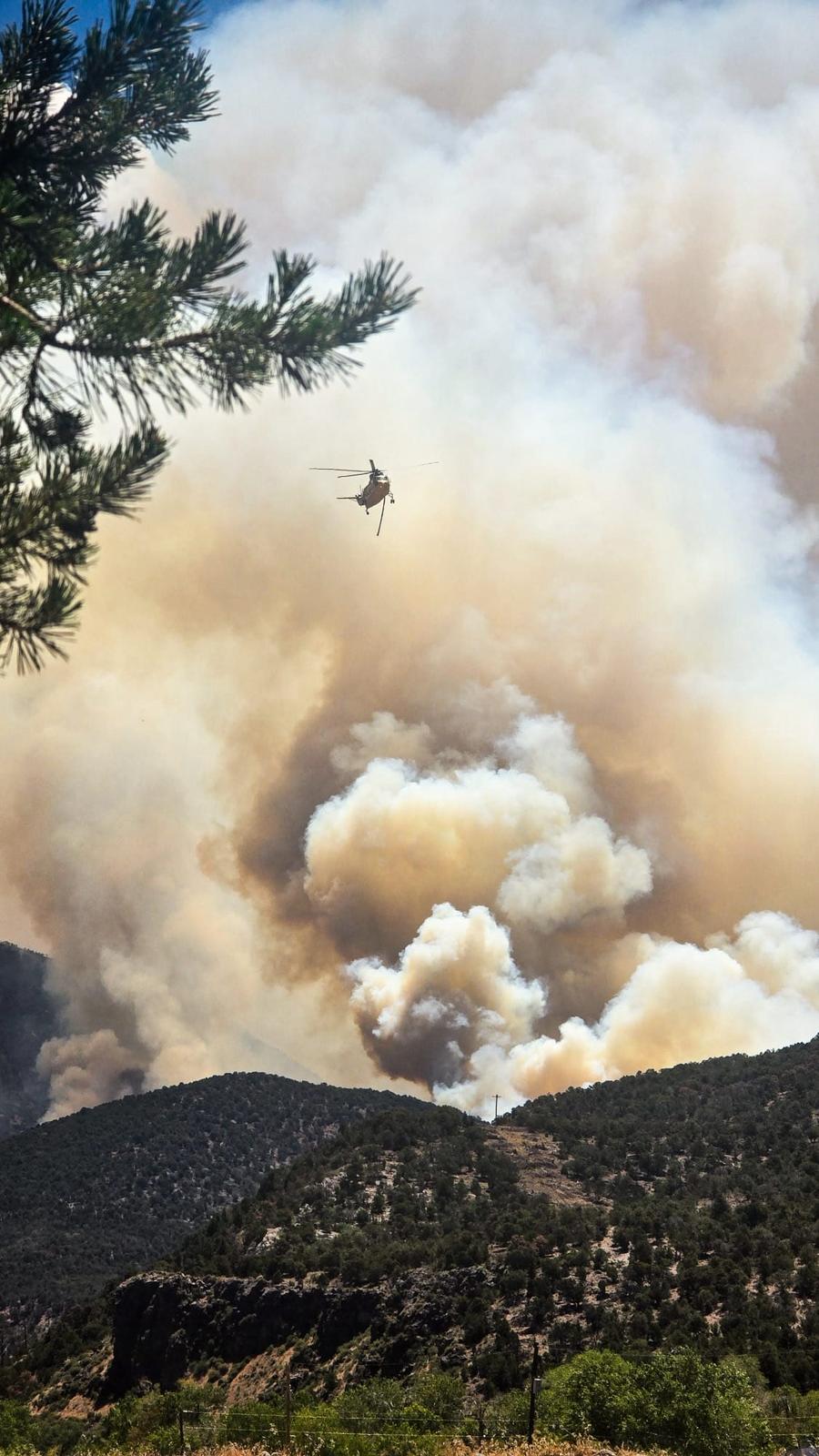 Helicopter flying over smoke billowing from the Cottonwood Fire